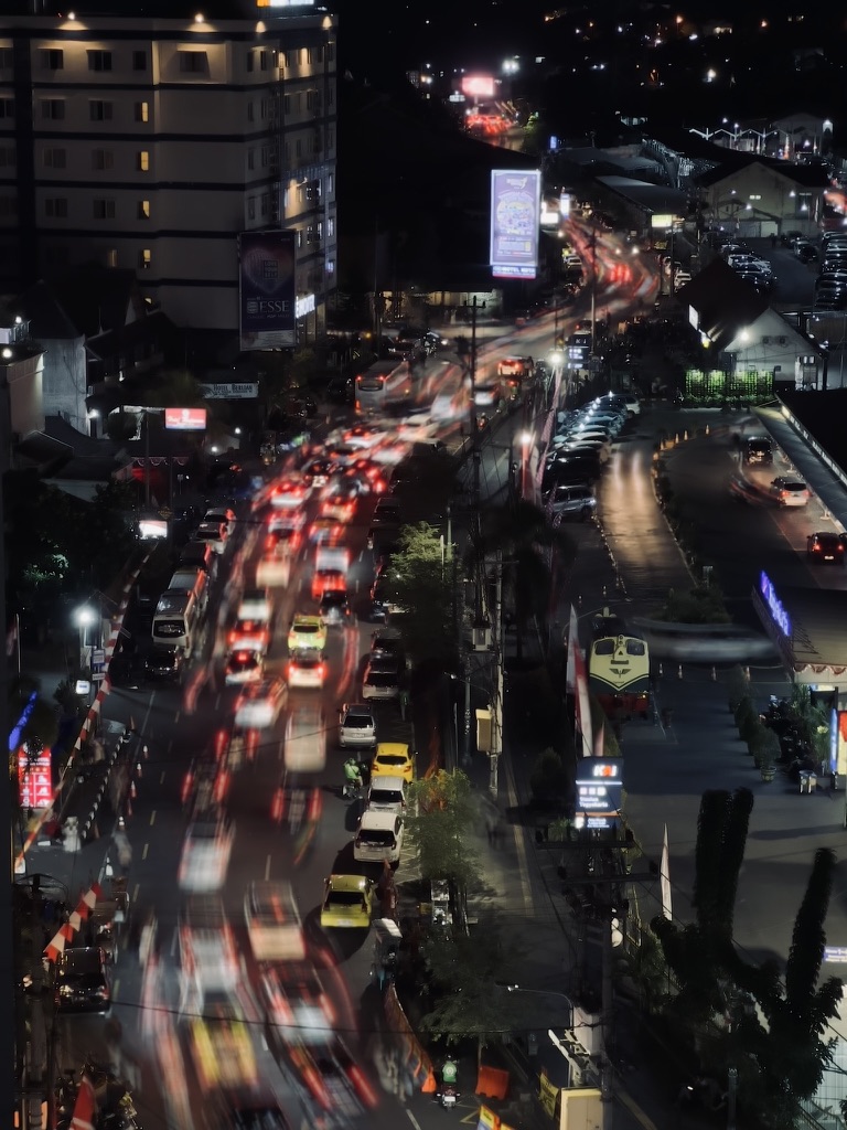Streams of traffic moving through an Indonesian city at night