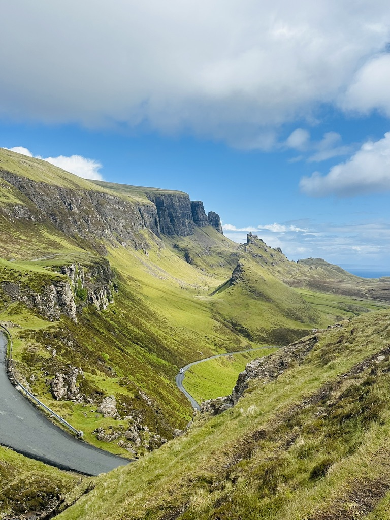 Single-track road winding through green hills