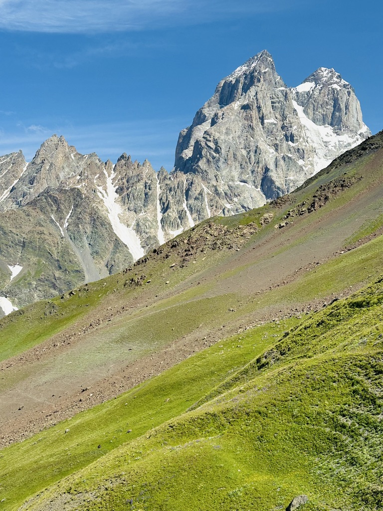 Twin rock summits rising above a green ridge